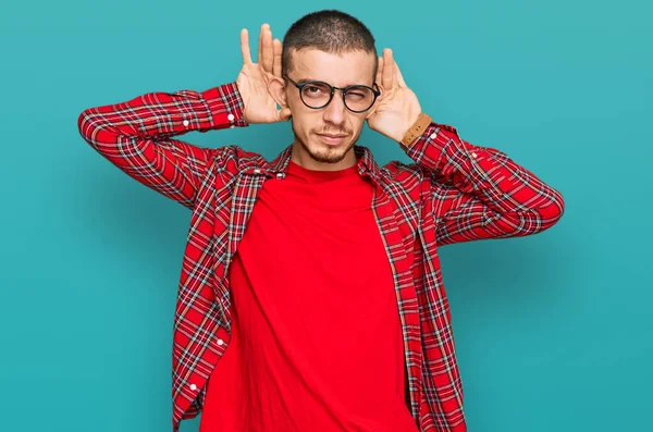 Jovem Hispânico Vestindo Roupas Casuais Tentando Ouvir Ambas Mãos Gesto — Fotografia de Stock