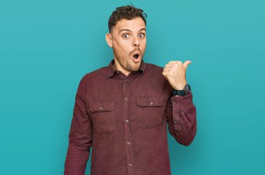 Gündelik giysiler giyen genç İspanyol adam elleri yana doğru işaret ederek şaşırdı, ağzı açık hayret içinde kaldı.. 