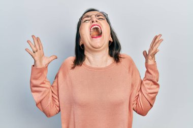 Orta yaşlı İspanyol kadın gündelik kıyafetler giyiyor ve gözlük takıyor. Başarının çılgınlığını kutluyor. Kollarını kaldırmış, gözlerini kapatmış heyecanlı çığlıklar atıyor. Kazanan konsept 