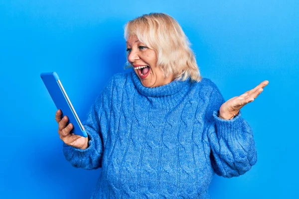 Mujer Rubia Mediana Edad Utilizando Dispositivo Táctil Celebrando Victoria Con —  Fotos de Stock
