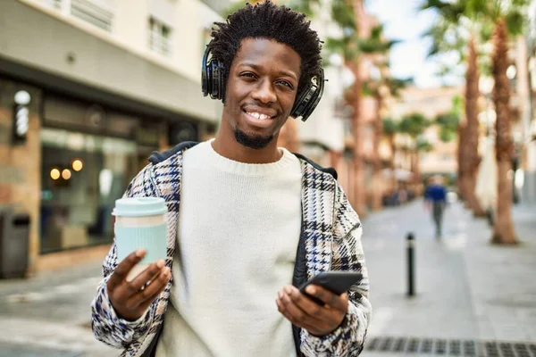 Afro Saçlı Kulaklık Takan Akıllı Telefon Kullanarak Müzik Dinleyen Yakışıklı — Stok fotoğraf