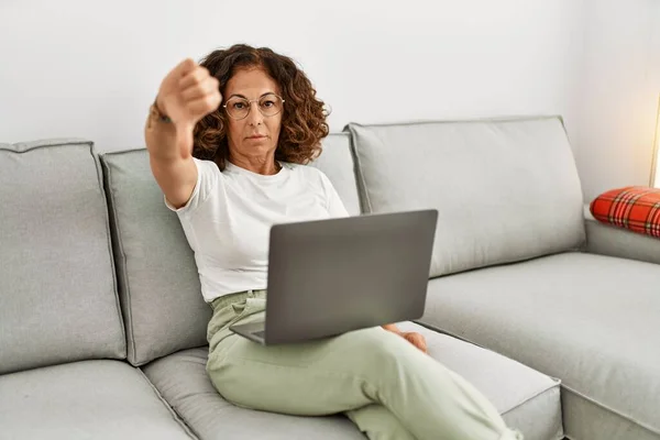 中年时 他的恐慌女人在家里用电脑笔记本电脑 满脸怒容 消极的迹象表明她不喜欢大拇指朝下 拒绝的概念 — 图库照片