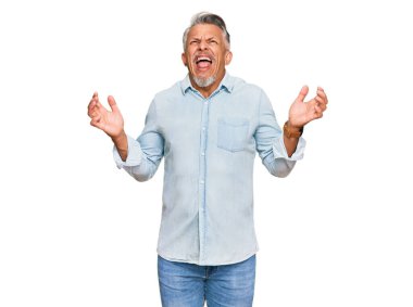 Orta yaşlı, gri saçlı, sıradan kıyafetler giyen çılgın ve kızgın bir adam agresif bir ifadeyle bağırıyor ve kollarını kaldırıyor. hüsran kavramı. 