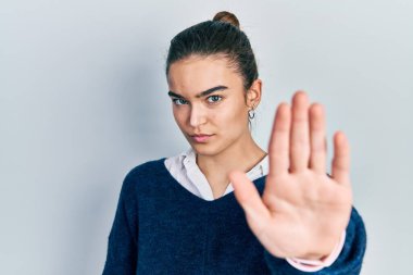 Günlük kıyafetler giyen genç beyaz kız avucunun içi gibi şarkı söylemeyi kesiyor. Yüzünde olumsuz ve ciddi bir jest olan uyarı ifadesi. 