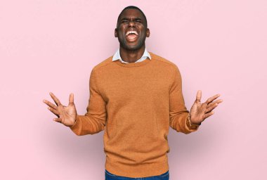 Sıradan kıyafetler giyen genç Afro-Amerikalı adam başarı için deli ve çılgınlığı kutluyor kollarını kaldırmış ve gözlerini kapatmış heyecanla bağırıyor. Kazanan konsept 