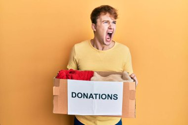 Kafkasyalı genç bir adam bağış kutusunu elinde tutuyor kızgın ve kızgın çığlıklar atıyor öfkeyle bağırıyor. öfke ve agresif konsept. 