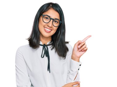 İş gömleği ve gözlük takan güzel Asyalı genç bir kadın gülümsüyor. 