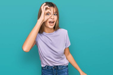 Kafkasyalı bir genç kız günlük giysiler giyiyor. Şaşırmış yüz ifadesiyle şoka girmiş, parmaklarının arasından bakıyor. İnançsız ifade. 