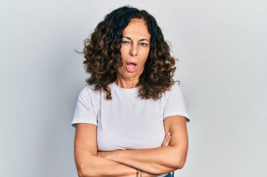 Orta yaşlı, kollarını kavuşturmuş, şok olmuş, şüpheci ve alaycı bakışlı, ağzı açık bir şekilde şaşırmış İspanyol bir kadın. 