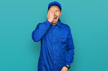 Sakallı, inşaatçı tulumu giymiş, kel bir adam. Yarı yüz, yarı göz, yarı ağız, esneme yorgunluğu çekiyor. Yüzüm acıyor.. 