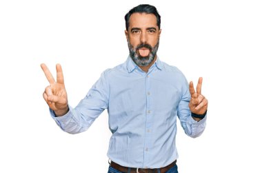 Orta yaşlı, sakallı, iş gömleği giyen, ağzı açık gülümseyen, iki elini de zafer işareti yapan bir adam. İki numara.. 