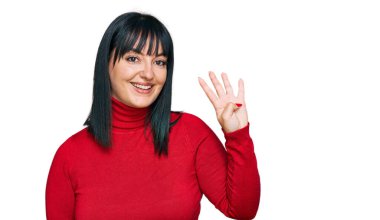 Genç İspanyol kadın gündelik giysiler giyer ve parmaklarını dört numarayı göstererek gülümserken kendinden emin ve mutlu.. 