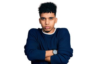 Gündelik kıyafetler giyen, kuşkucu ve gergin genç Afro-Amerikalı bir adam. Yüzünde çapraz kollarla onaylamayan bir ifade var. negatif kişi. 