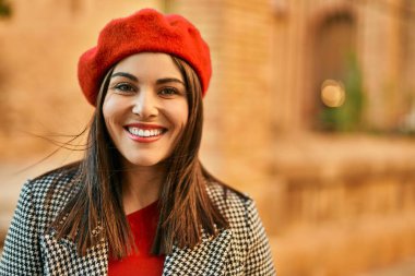 Genç İspanyol kadın gülümseyerek şehirde mutlu mesut dikiliyor..