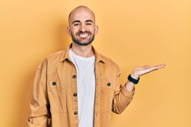 Genç kel adam avuçlarını açmış elinde mutlu ve havalı bir gülümsemeyle gülümseyen bir şey tutuyordu. diş gösterme. 