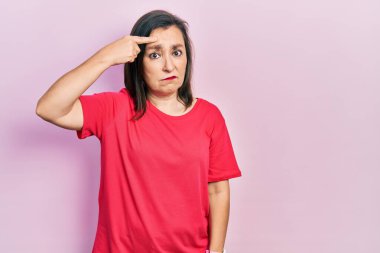 Orta yaşlı, sıradan kıyafetler giyen, alnındaki sivilceden mutsuz, siyah başlıklı, çirkin enfeksiyonlu bir kadın. sivilce ve deri problemi 