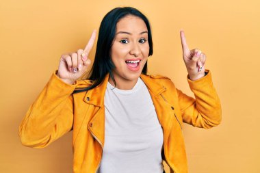 Sarı deri ceketli, güzel İspanyol bir kadın. Şaşırmış, şaşırmış, parmaklarıyla işaret ediyor ve kollarını kaldırıyordu.. 