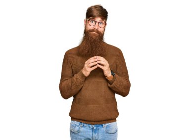 Genç İrlandalı kızıl saçlı, günlük kıyafetler ve gözlük takan elleri birleştirip gülümseyerek gevşemiş ve neşeliydi. Başarı ve iyimserlik 