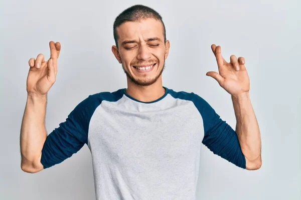 Giovane Ispanico Che Indossa Abiti Casual Gesticolando Dito Incrociato Sorridendo — Foto Stock