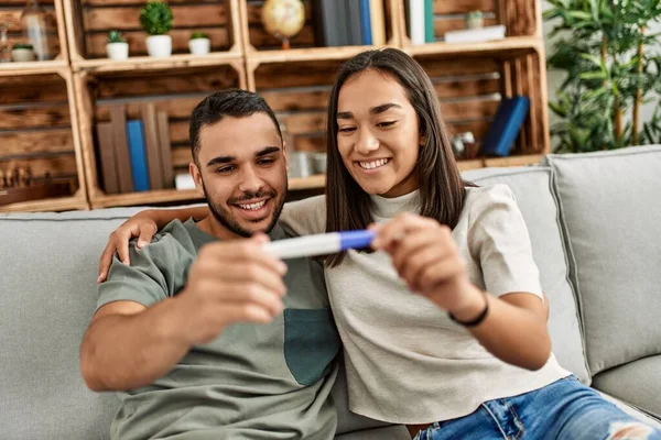 Młoda Latynoska Para Uśmiechnięta Szczęśliwie Wyglądająca Ciąży Wynik Testu Domu — Zdjęcie stockowe