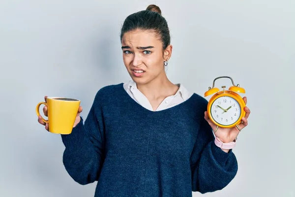 コーヒーと目覚まし時計を持っている若い白人の少女は 混乱した表情 疑わしい概念 — ストック写真