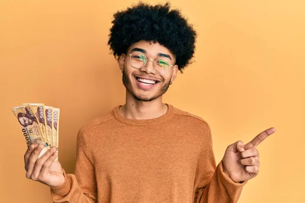 年轻的非洲裔美国人 留着5000张饥饿的福林钞票 满面春风 手指手画脚地微笑着 — 图库照片
