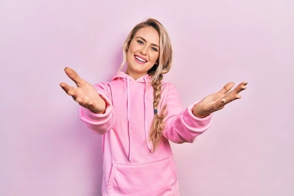 Mooie Jonge Blonde Vrouw Draagt Roze Sweatshirt Kijkt Naar Camera — Stockfoto