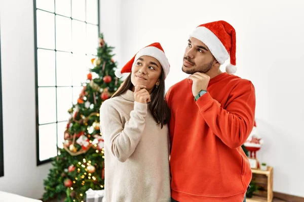 Genç Spanyol Çift Noel Ağacının Yanında Elleri Çenelerinde Soru Sorarken — Stok fotoğraf