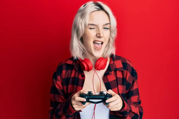 Giovane Ragazza Bionda Che Gioca Videogame Tenendo Controller Ammiccante Guardando — Foto Stock