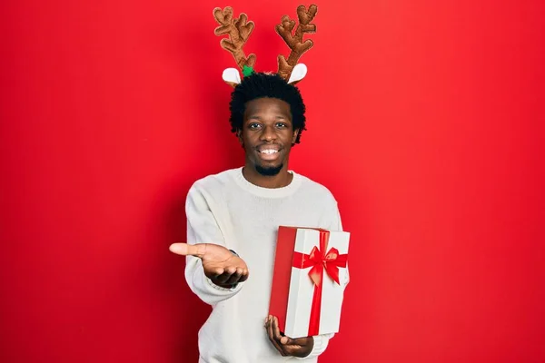 Jovem Afro Americano Vestindo Veado Chapéu Natal Segurando Presente Sorrindo — Fotografia de Stock