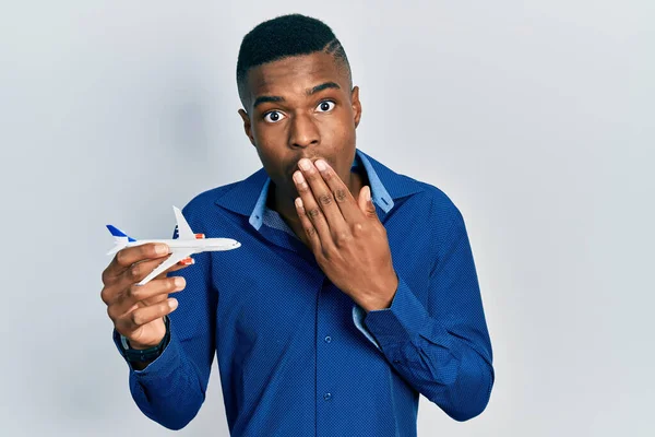 Ung Afrikansk Amerikansk Man Håller Flygplan Leksak Täcker Munnen Med — Stockfoto