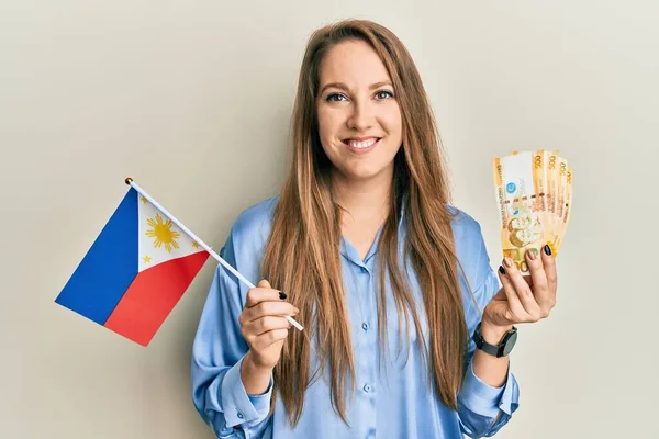 Young Blonde Woman Holding Philippine Flag Philippines Pesos Banknotes Smiling — Stock Photo, Image