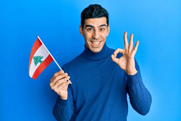 Pohledný Hispánec Držící Libanonskou Vlajku Dělá Pořádku Znamení Prsty Usmívá — Stock fotografie