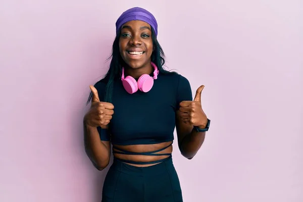 Junge Afrikanisch Amerikanische Frau Turnbekleidung Und Mit Kopfhörern Erfolgszeichen Tun — Stockfoto