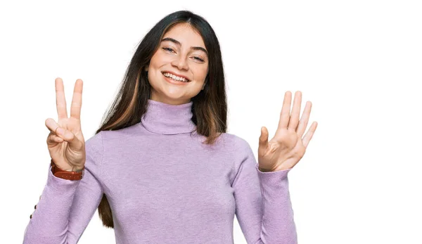 터틀넥 스웨터를 자신감 행복하게 웃으면서 손가락으로 가리키는 아름다운 — 스톡 사진
