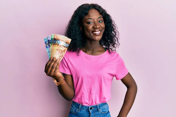 Krásná Africká Mladá Žena Drží Kanadské Dolary Vypadá Pozitivně Šťastně — Stock fotografie