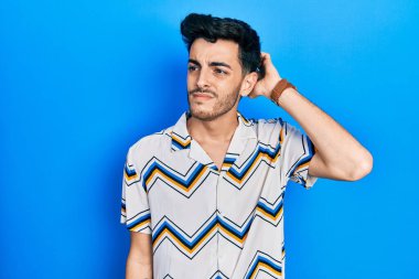 Gündelik kıyafetler giyen genç İspanyol adam soru sorup kafasını karıştırıyor. Şüpheyle kararsız, kafa kafaya düşünerek. Düşünceli kavram. 
