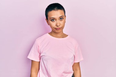 Kısa saçlı, sıradan pembe tişörtlü güzel bir İspanyol kadın depresyonda ve sıkıntıdan korkuyor, kızgın ve korkmuş. hüzünlü ifade. 