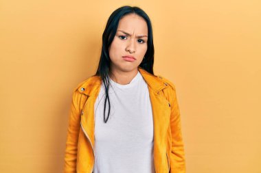 Burnu delinmiş, sarı deri ceket giyen, kederli, sinirli ve korkmuş bir İspanyol kadın. hüzünlü ifade. 