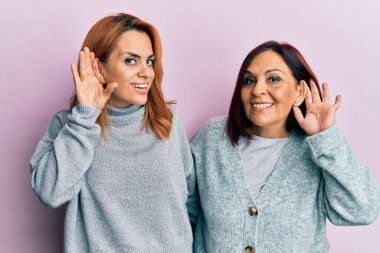 Latin anne ve kızı, gündelik kıyafetler giyip, sırıtarak dedikodu ve dedikodulara kulak misafiri oluyorlar. Sağırlık kavramı. 