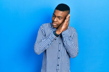 Genç Afro-Amerikan adam günlük kıyafetler giyip uyuyordu. Yorgundu. Hayal kuruyordu ve elleriyle poz veriyordu.. 