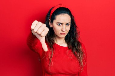 Gündelik kıyafetler giyen genç İspanyol kadın mutsuz görünüyor ve reddediliyor ve olumsuz bir hareket yapıyor. kötü ifade. 