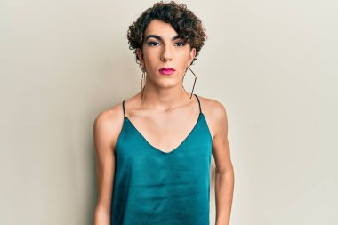 Makyaj yapan genç transseksüel bir adam ve kadın giysileri, moda ve göz kamaştırıcı görünüyor.