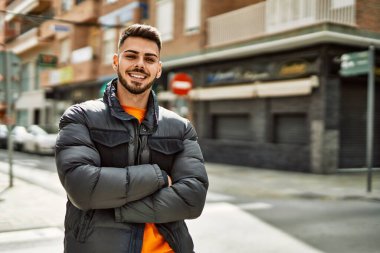 Yakışıklı, sakallı, neşeli ve kendine güvenen, kışlık palto giyen bir İspanyol.