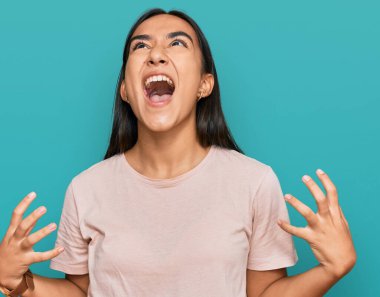 Genç Asyalı kadın gündelik kıyafetler giyip deli gibi bağırıyor ve agresif bir ifade ve kollarla bağırıyor. hüsran kavramı. 