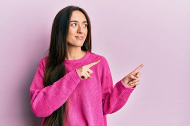 Genç İspanyol kız parmaklarını kenarı işaret ediyor gülümsüyor yan tarafa bakıyor ve düşünüyor.. 