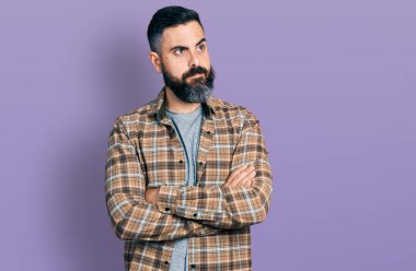 Kollarını kavuşturup gülümseyen sakallı İspanyol bir adam.. 