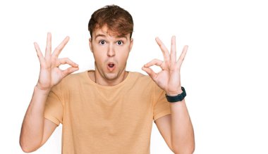 Gündelik giysiler giyen genç beyaz adam şaşırmış ve şok olmuş görünüyor. çılgın ifade 