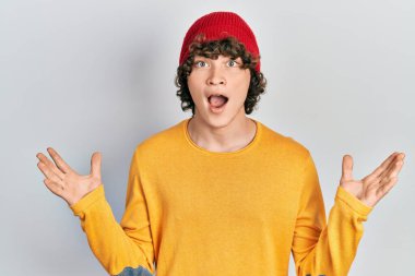 Yün şapka takan yakışıklı genç adam çılgın ve başarıyı kollarını kaldırıp heyecanla haykırarak kutluyor. Kazanan konsept 