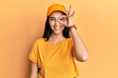 Genç İspanyol kadın teslimat üniforması ve şapkası giyiyor. El hareketleriyle gülümsüyor, gözleriyle mutlu yüzlere bakıyor.. 